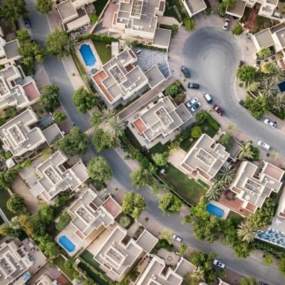 Explore a stunning aerial view of a residential area in Dubai with lush greenery and swimming pools.